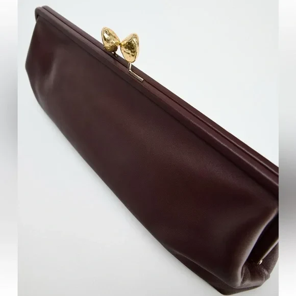 Elongated metal trim leather clutch bag