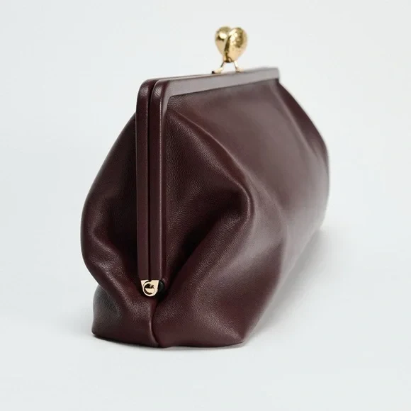 Elongated metal trim leather clutch bag