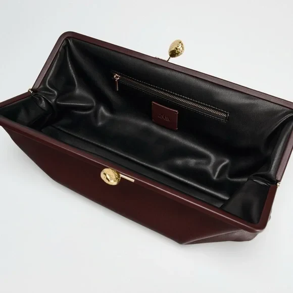 Elongated metal trim leather clutch bag