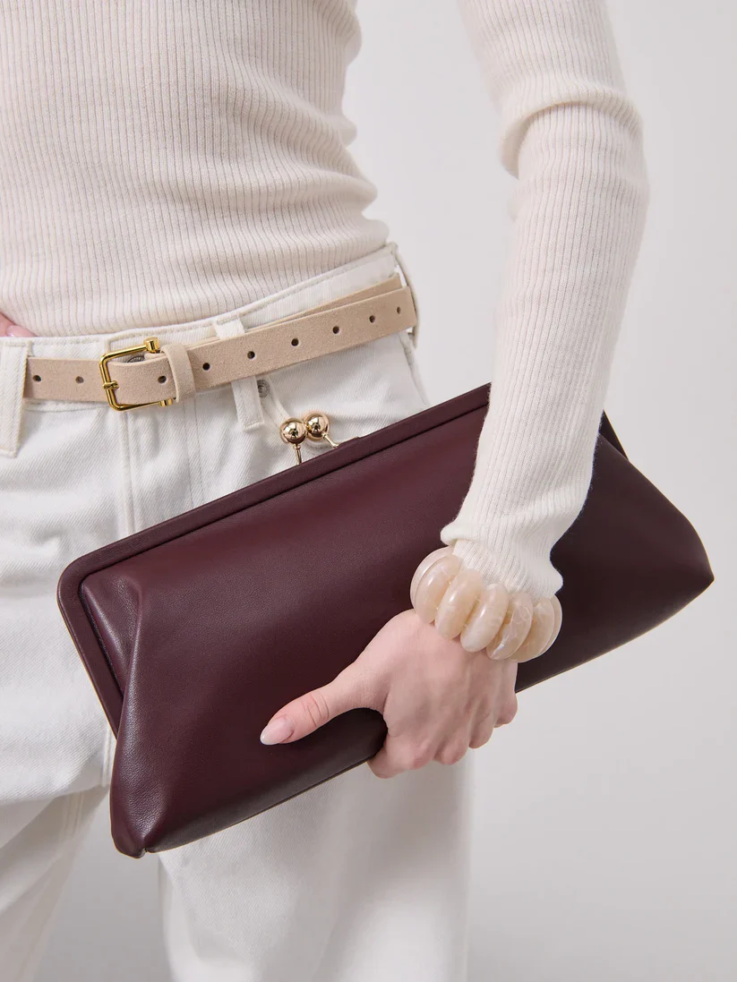 Elongated metal trim leather clutch bag