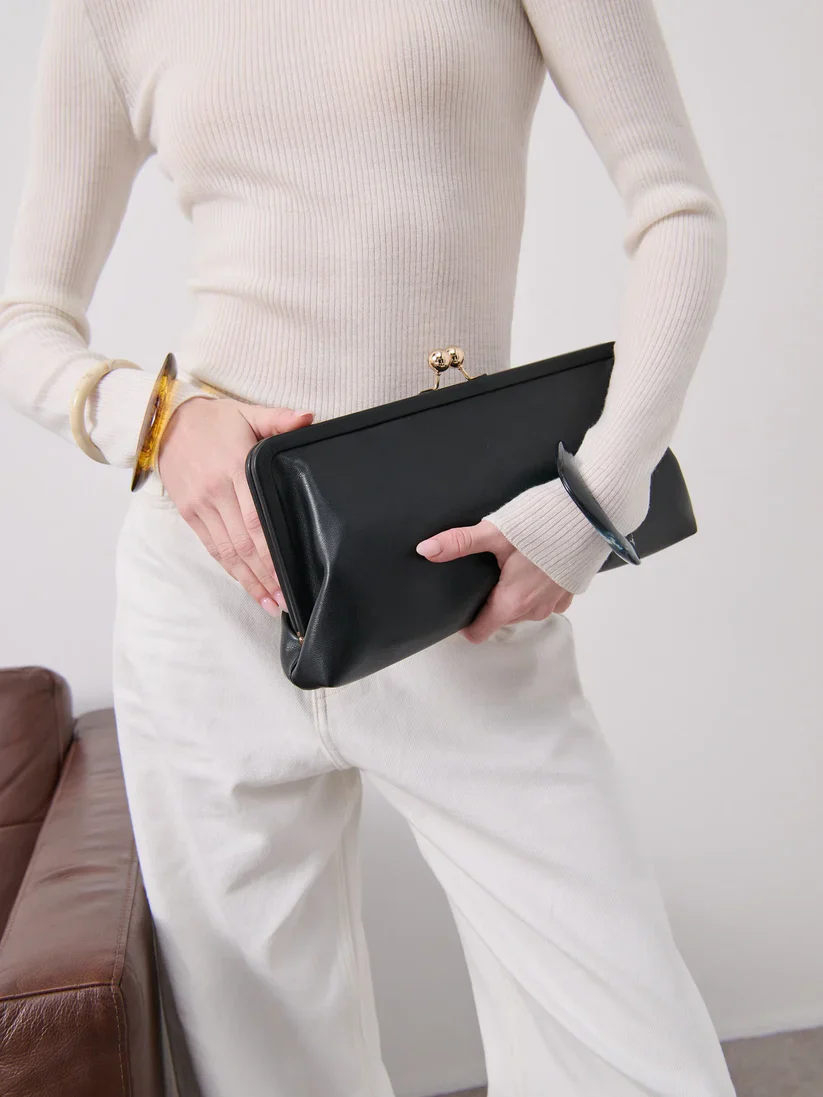 Elongated metal trim leather clutch bag