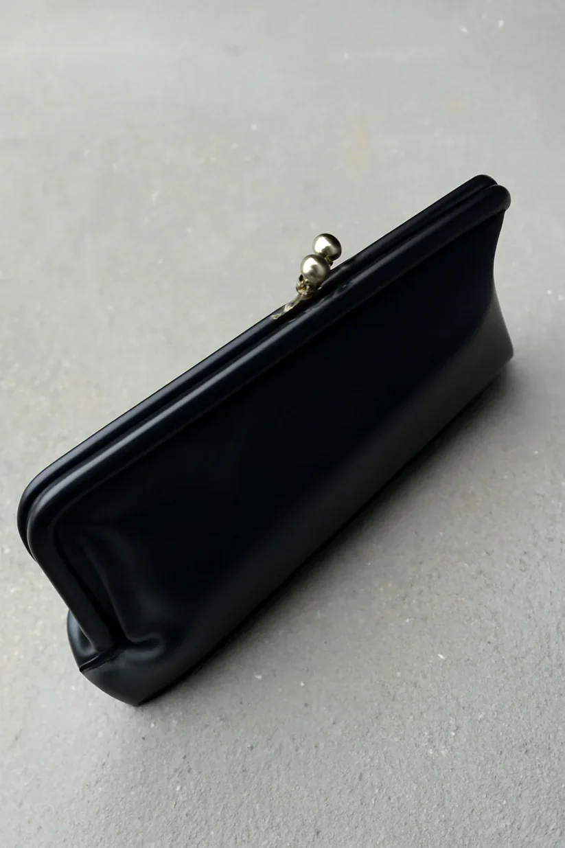 Elongated metal trim leather clutch bag