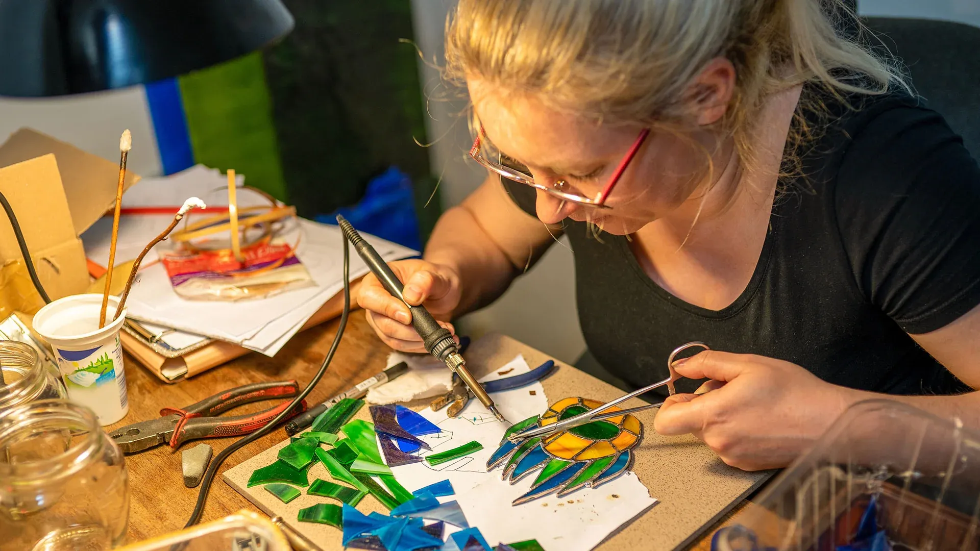 Artisan soldering stained glass by hand