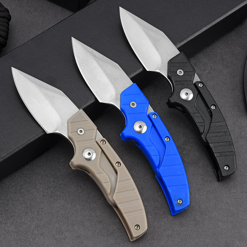 Three folding knives with different colored handles on a dark surface