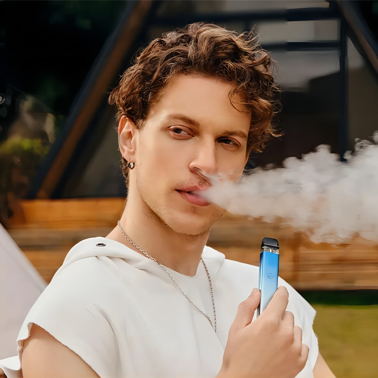 Man vaping XROS 3 blue vape, emphasizing a modern lifestyle