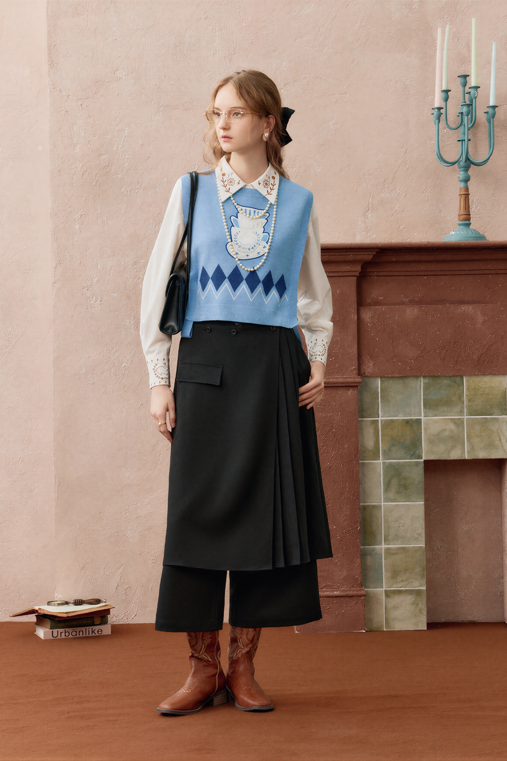 Short knitted vest worn over a tank top