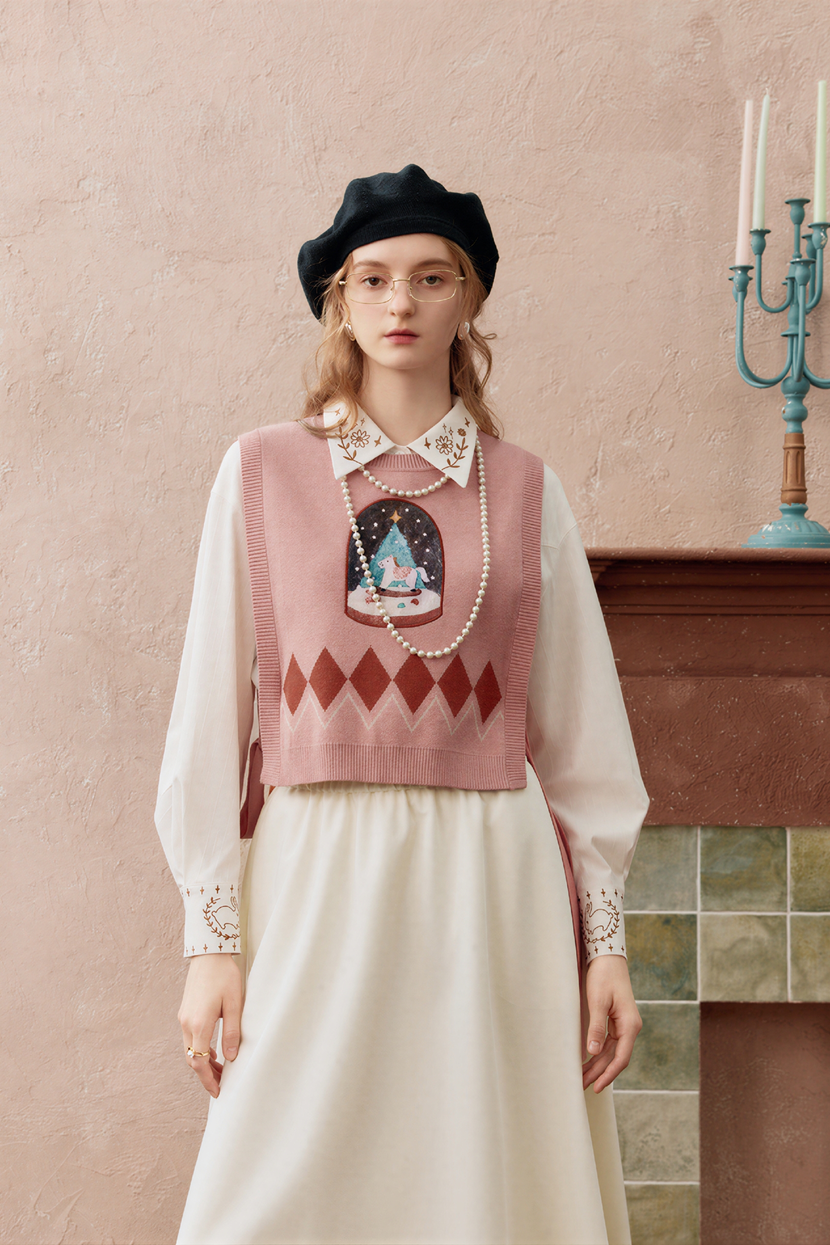 Short knitted vest worn over a tank top