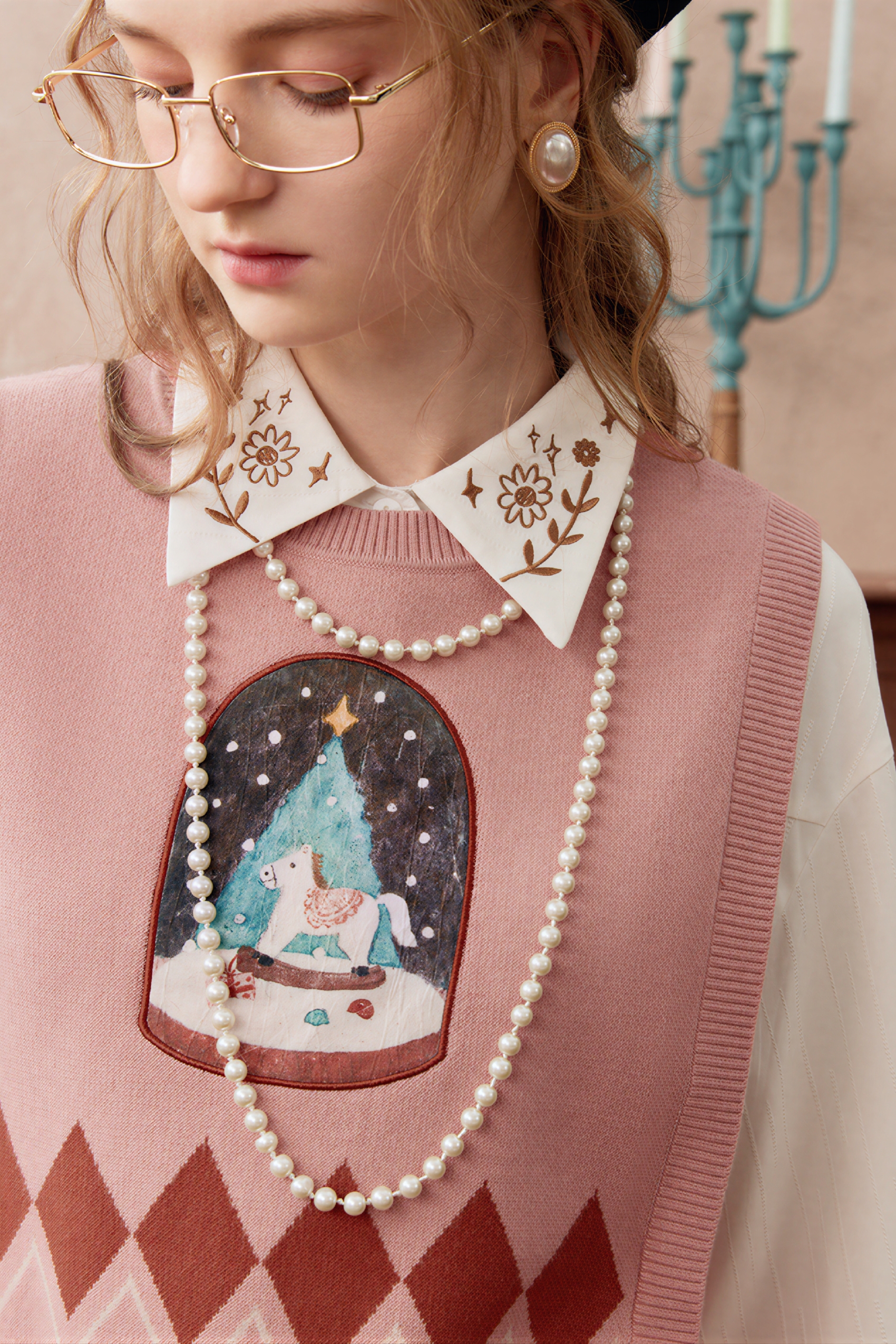 Short knitted vest worn over a tank top