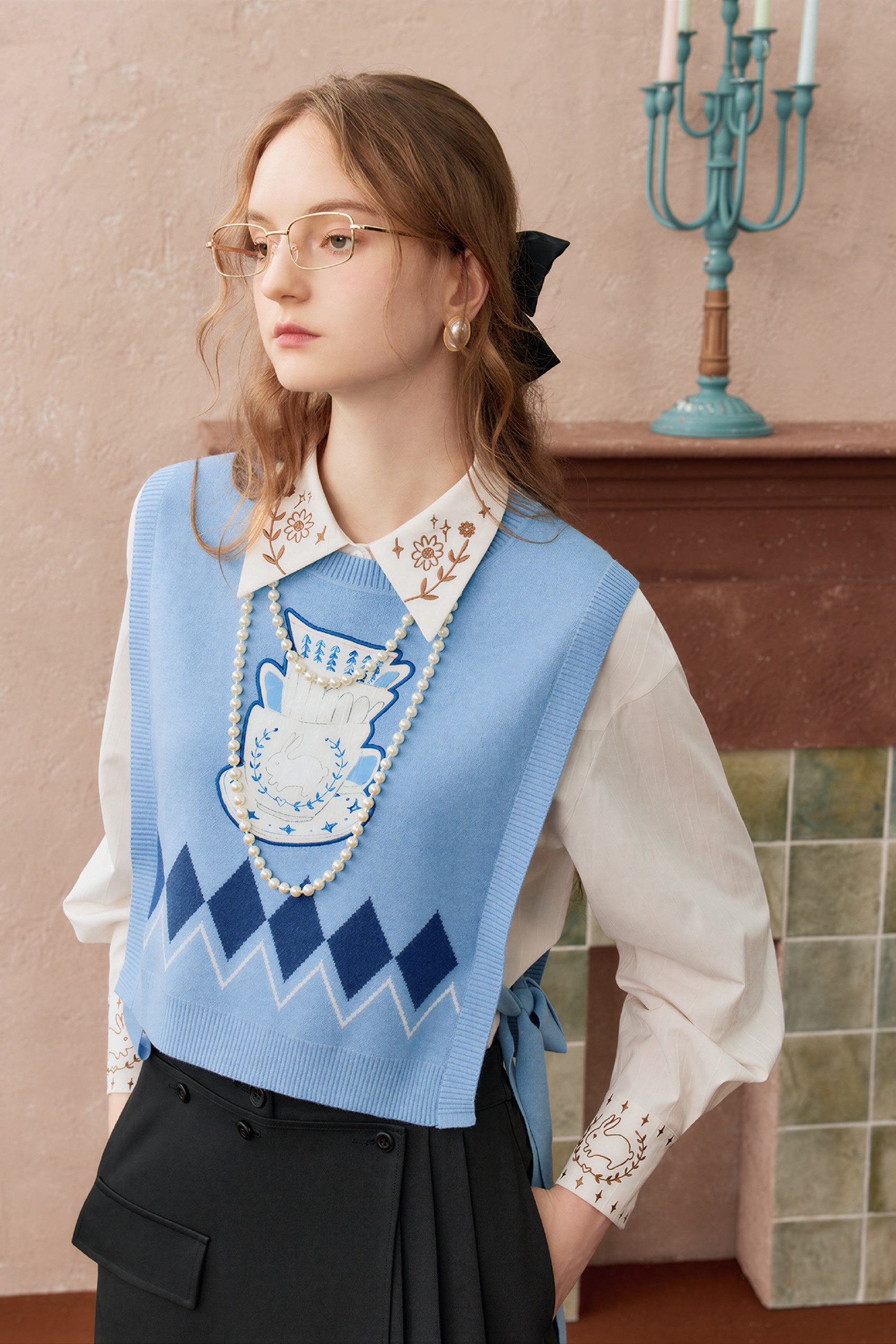 Short knitted vest worn over a tank top