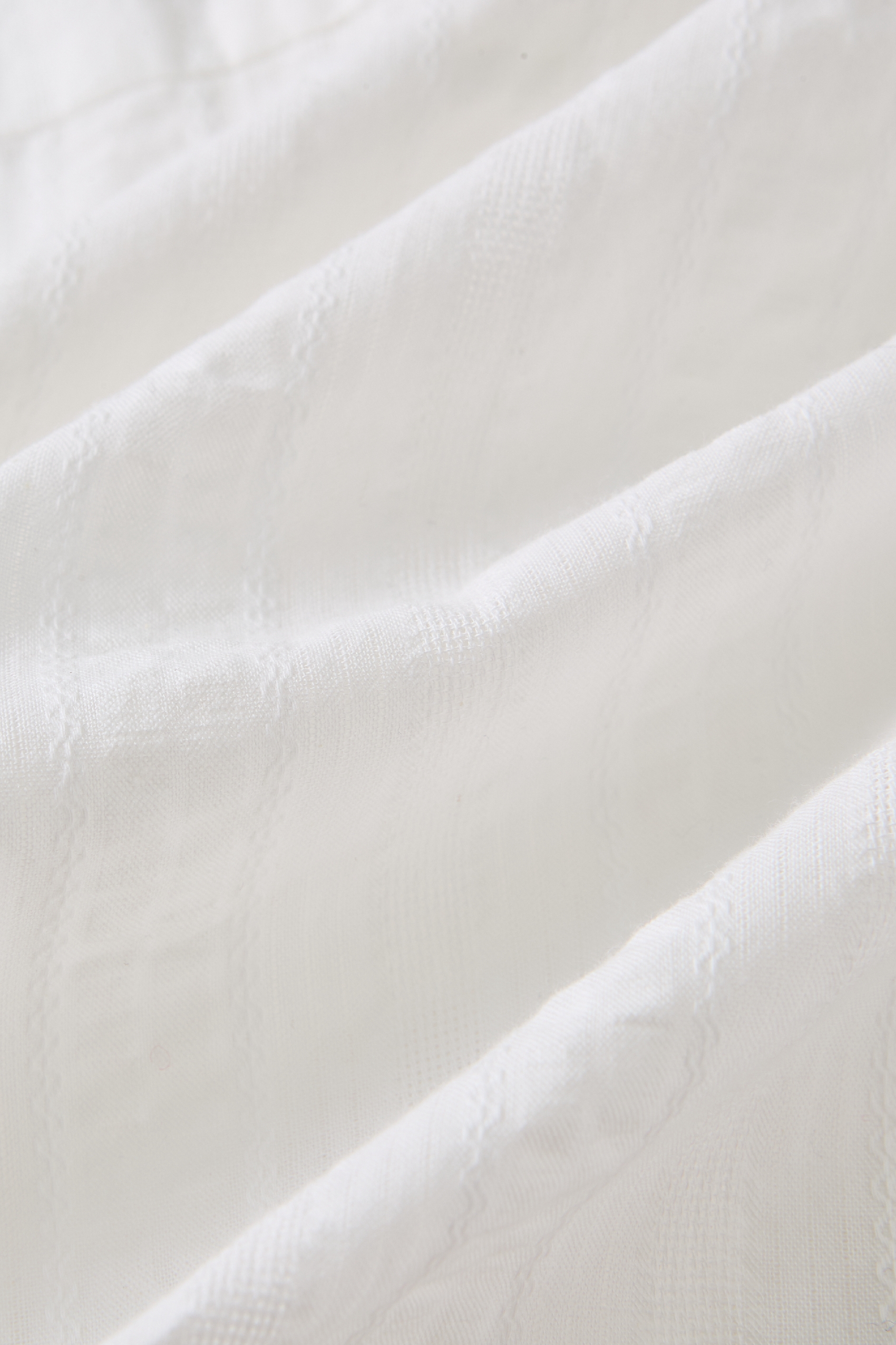 Close-up of soft white knit cardigan fabric