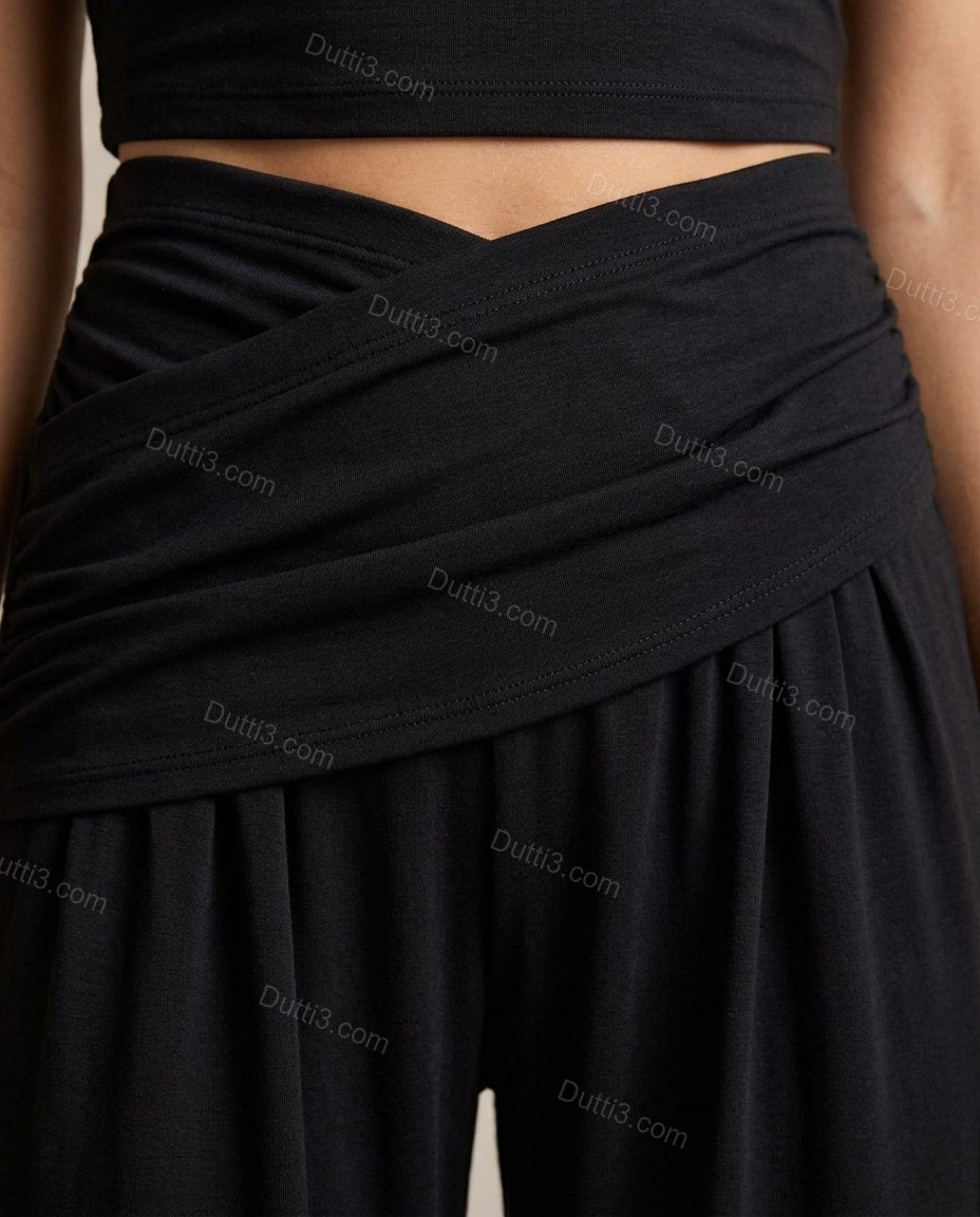 Black Top & Pants Set, close-up of crossover waistband, wrap-effect bodice and wide-leg silhouette, by Dutti3