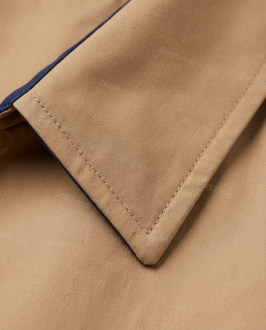 Tan Cotton Coat, close-up of navy blue accents, contrast facing and button front closure, by Dutti3