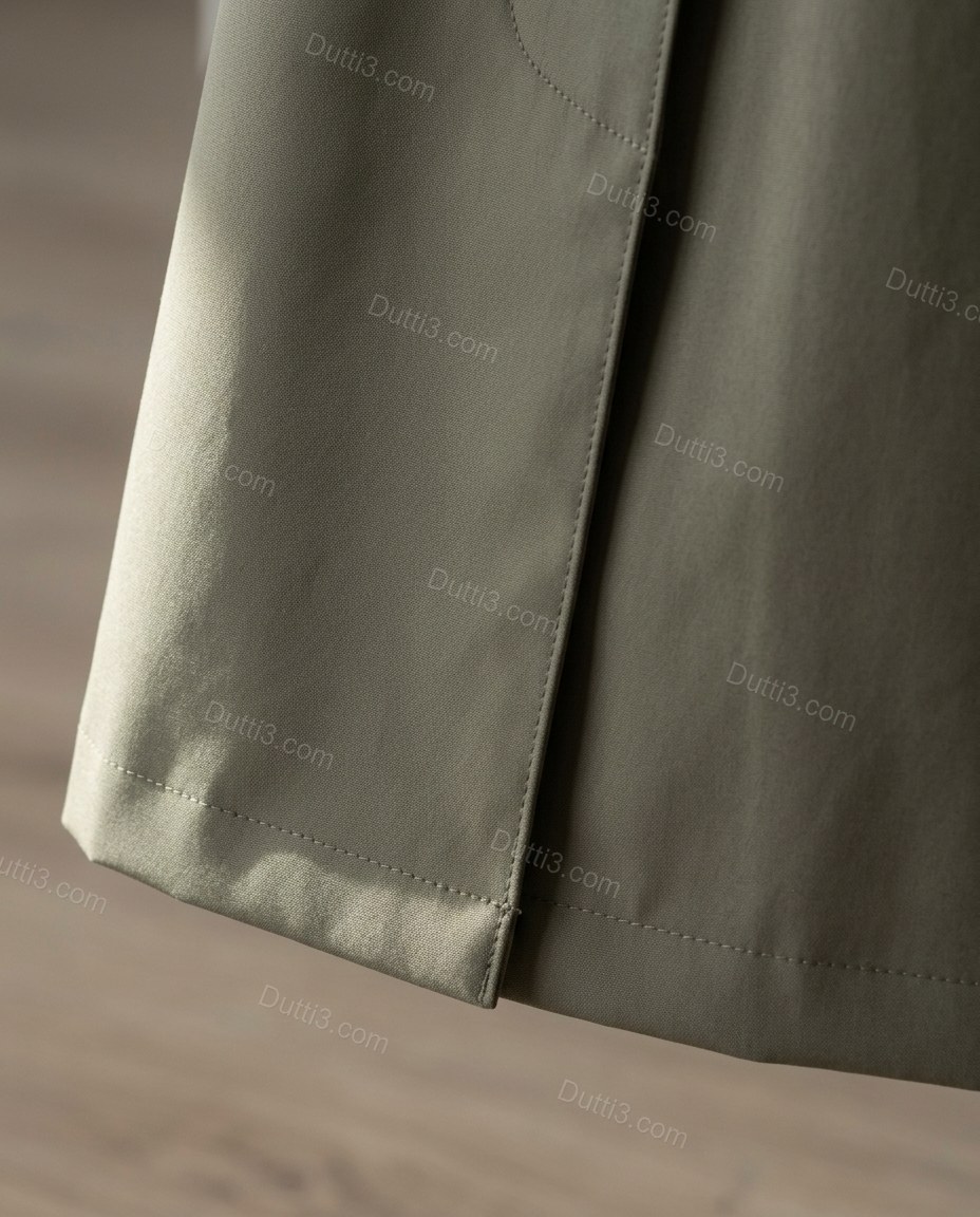 Olive Green Pleated Coat, close-up of belted waist, storm flap and button closure, by Dutti3
