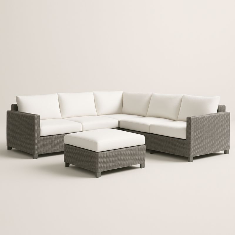 Canapé d'angle en rotin synthétique gris avec coussins blancs