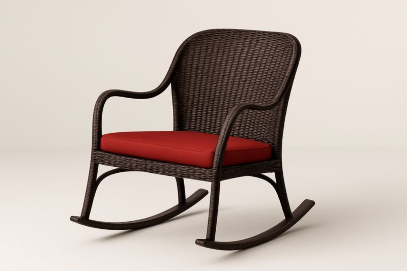 Chaise berçante en rotin brun avec coussin rouge