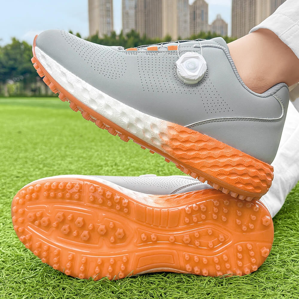 man wearing golf shoes on the grass orange outsole