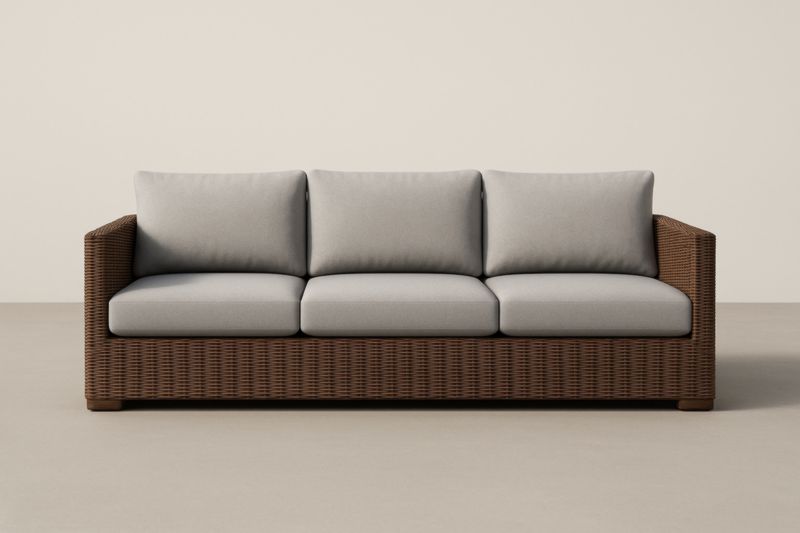 Divano a 3 posti in rattan marrone con cuscini grigi