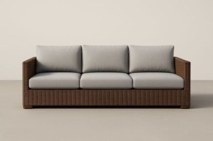 Divano a 3 posti in rattan marrone con cuscini grigi