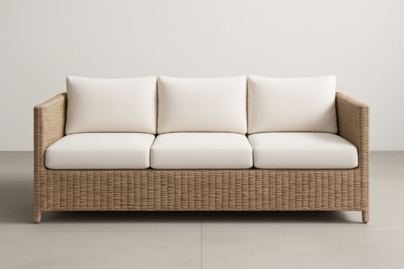 Divano a tre posti in rattan con cuscini bianchi