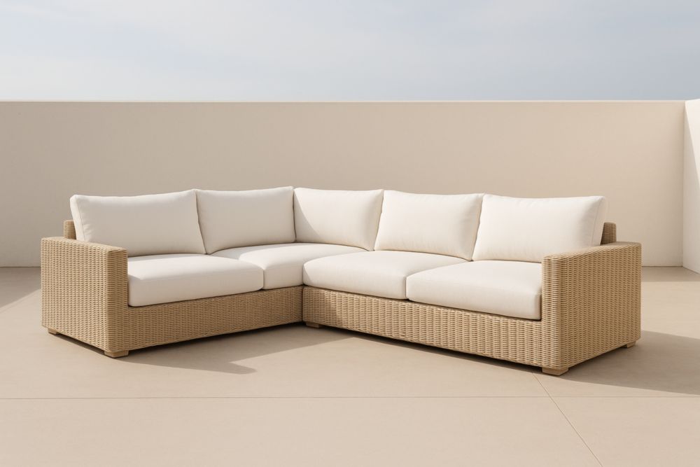 Divano angolare in rattan con cuscini bianchi