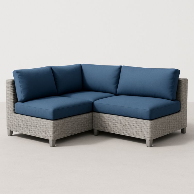 Divano angolare in resina intrecciata grigia con cuscini in poliestere blu