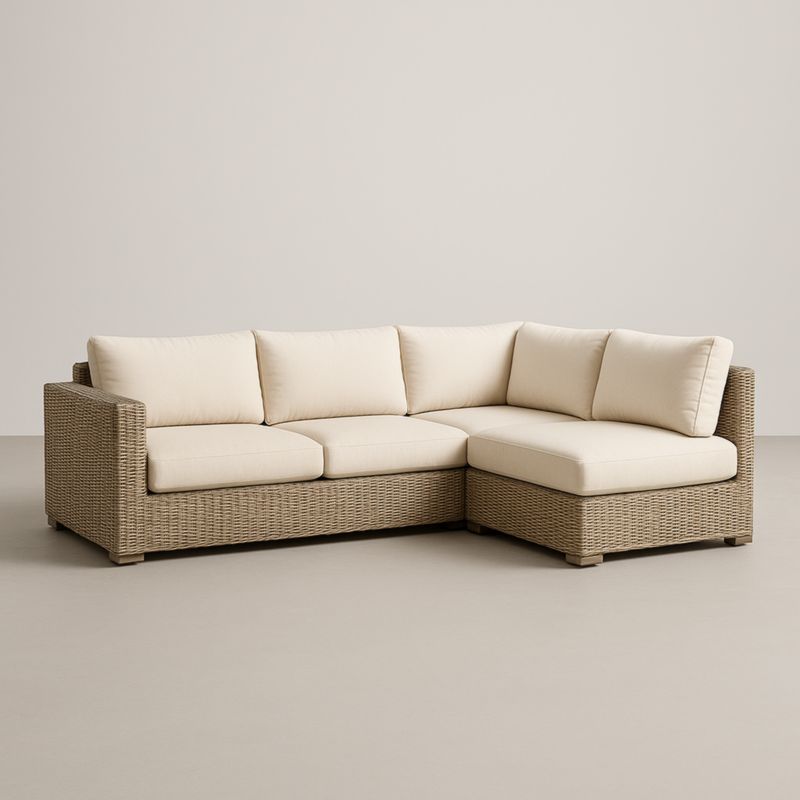 Divano angolare in rattan con cuscini in tessuto crema