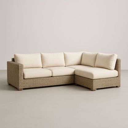 Divano angolare in rattan con cuscini in tessuto crema