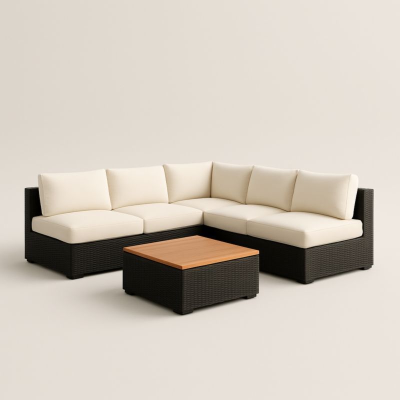 Divano angolare modulare in rattan nero con cuscini crema e tavolino in legno