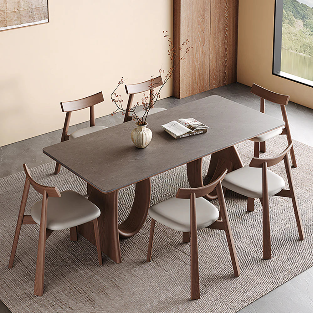Modern dining table with warm wood base and clean rectangular silhouette, styled in a minimalist dining space with neutral tones.
