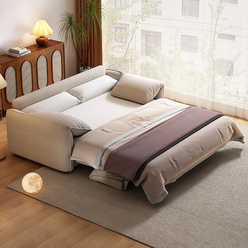 Beige sleeper sofa with a built-in spring mattress, fully extended into a bed in a modern, light-filled living space.
