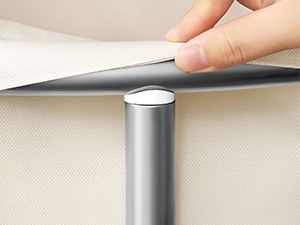 Cylindrical metal table leg being installed. Hand lifting tabletop to reveal silver support column underneath, demonstrating adjustable height mechanism.