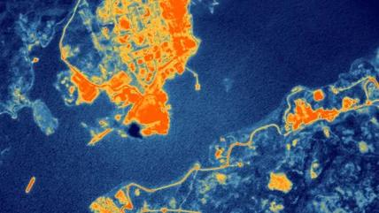 Thermal satellite image of industrial refinery showing heat signatures from processing units and storage tanks