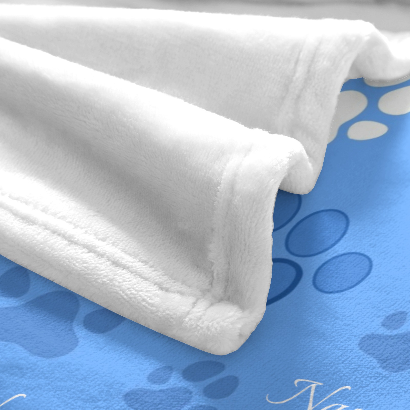 Decke mit Pfotenabdruckmuster und aufgedrucktem Haustiernamen.