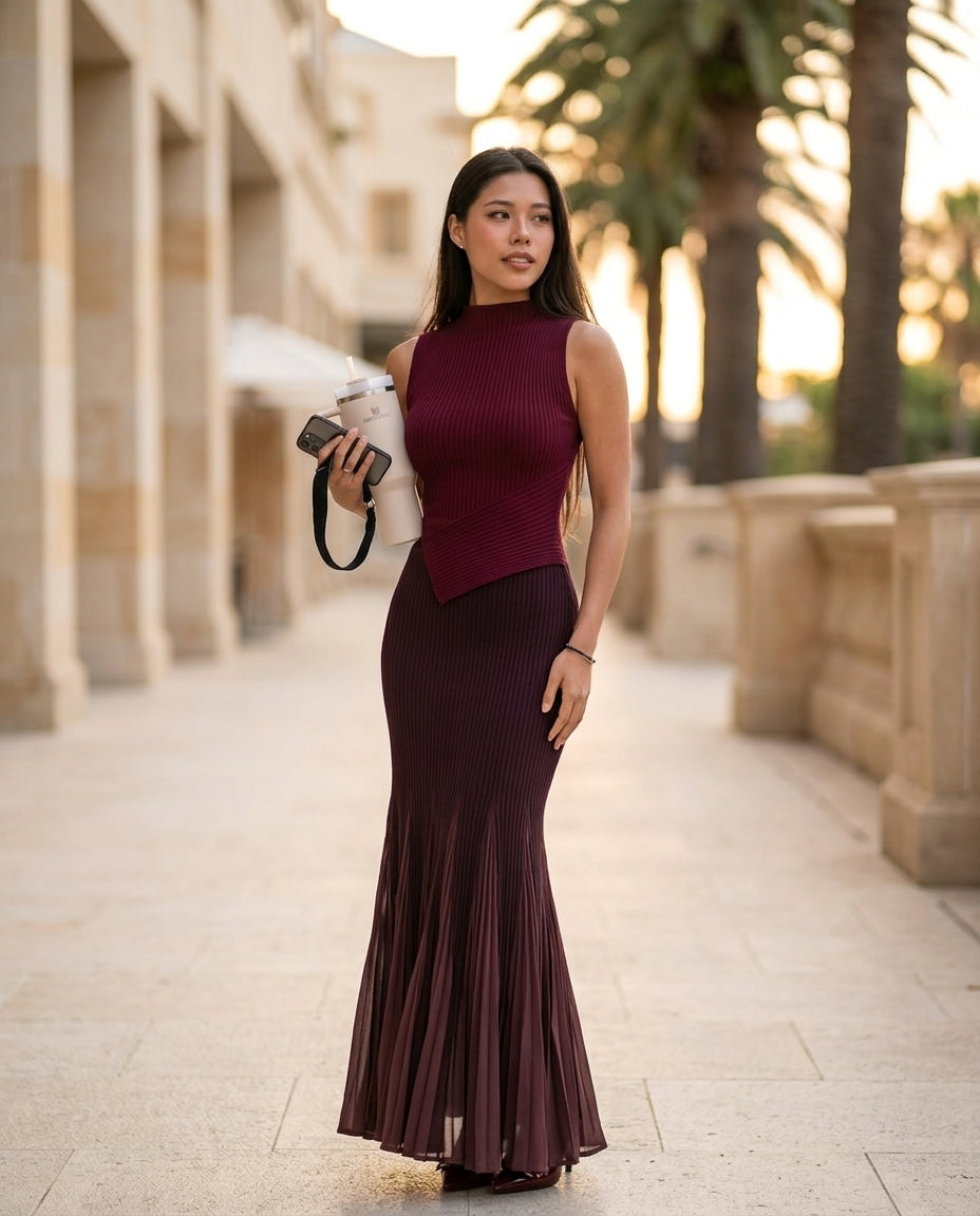 Burgundy Poise Summer Pleated Maxi Dress Burgundy Maxi Dress with Asymmetric silhouette and Ribbed Knit texture, lifestyle scene image for Resort Dinner, a private garden lunch, US East / Hamptons Elite by Massicos