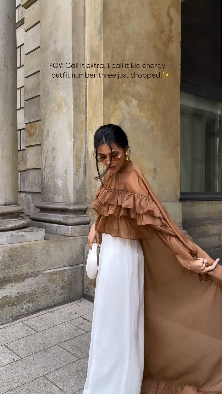 Ruffled cape-style top paired with wide-leg pants suit