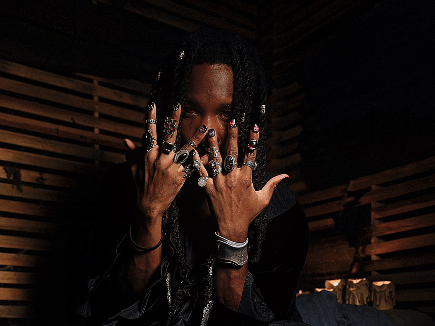 spooky halloween themed image of a man wearing the goth gate press on nail set, which features a raised 3D gate design over a deep red nail base