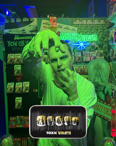 spooky Halloween themed image of a man wearing the Toxic Waste press on nail set, which features a dipped and splattered paint effect with a mixture of white, yellow, and black 