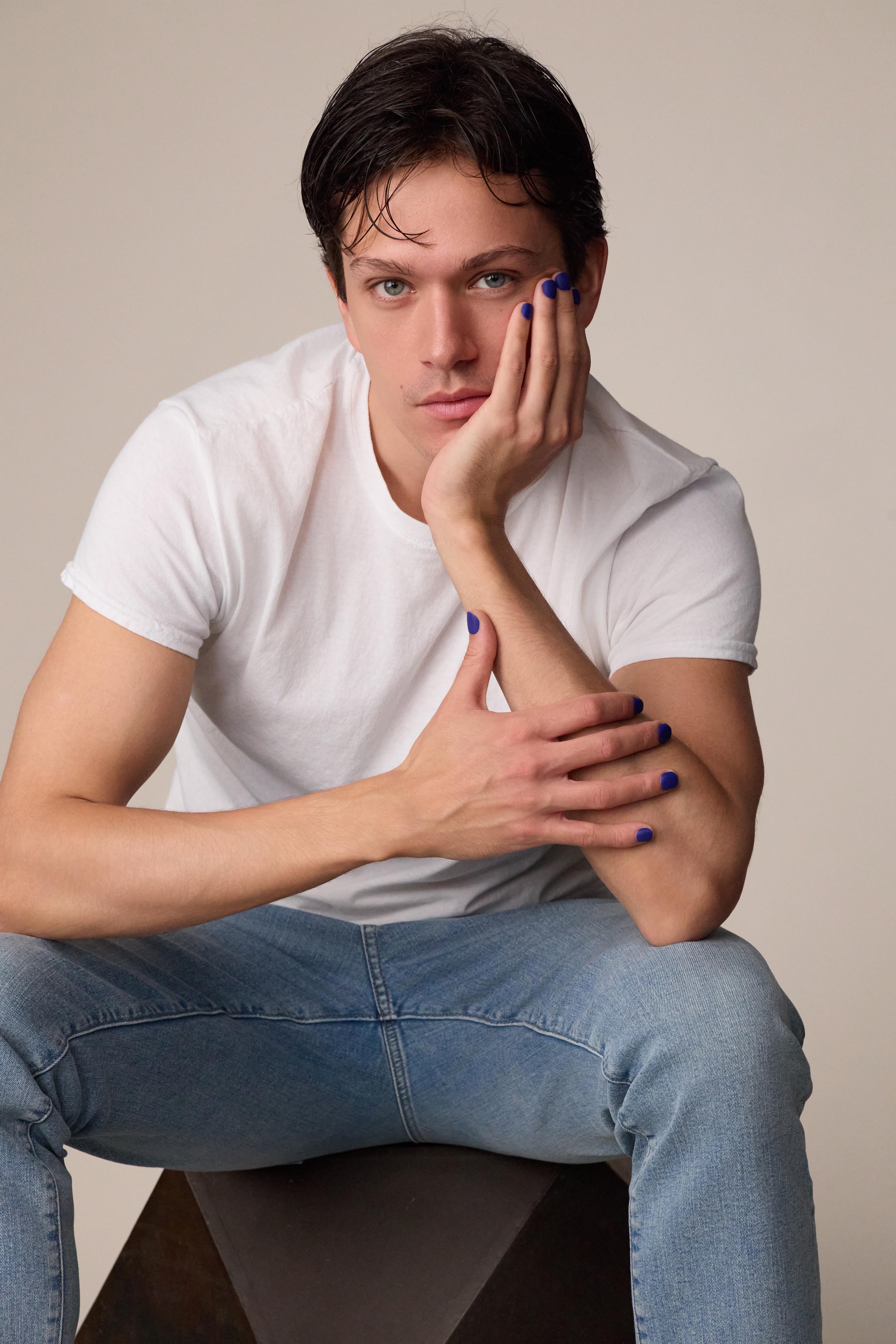 image of man wearing white shirt and jeans, showing men's press on nails in cobalt blue color