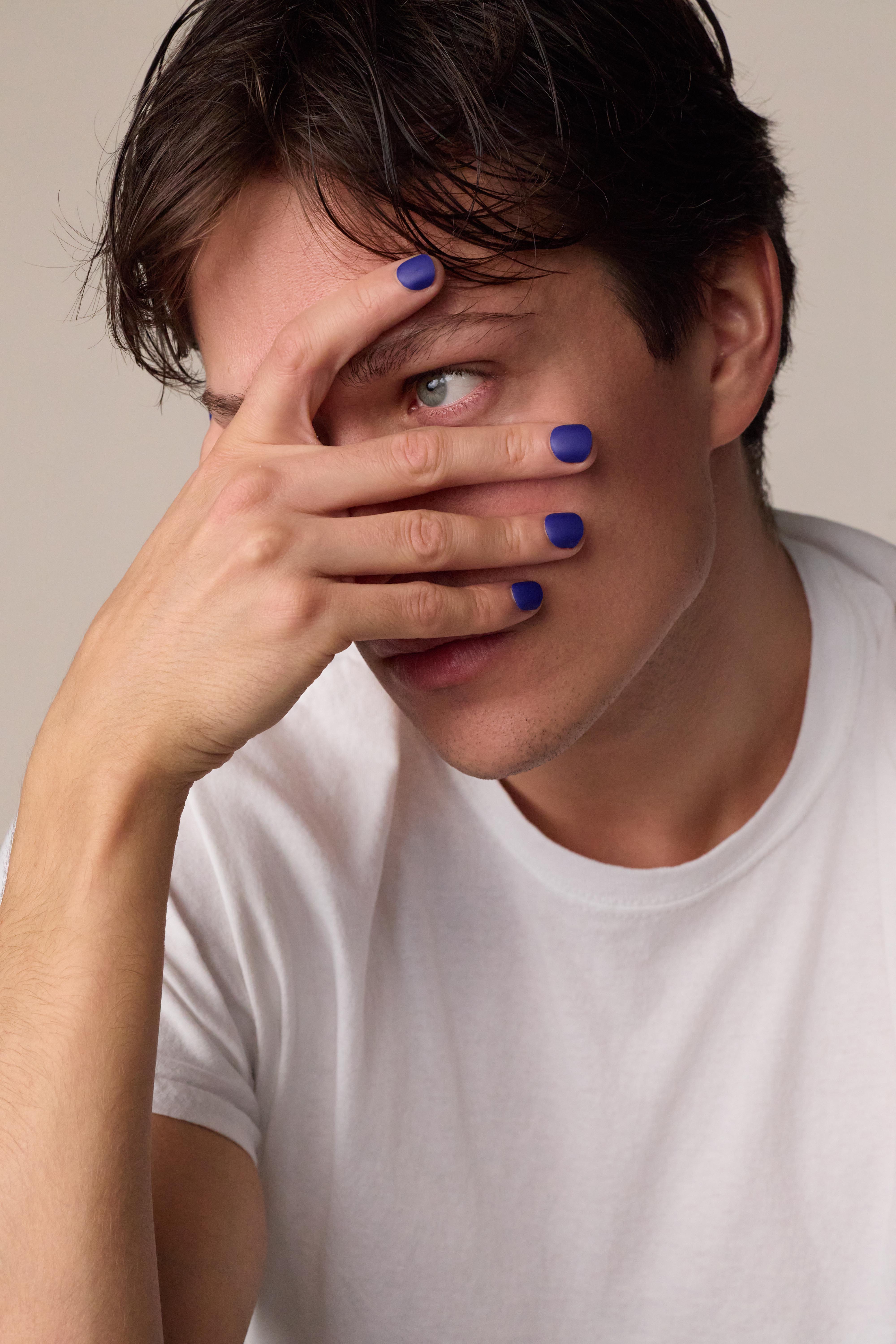 image of man in white shirt showcasing men's press on nails in matte cobalt color