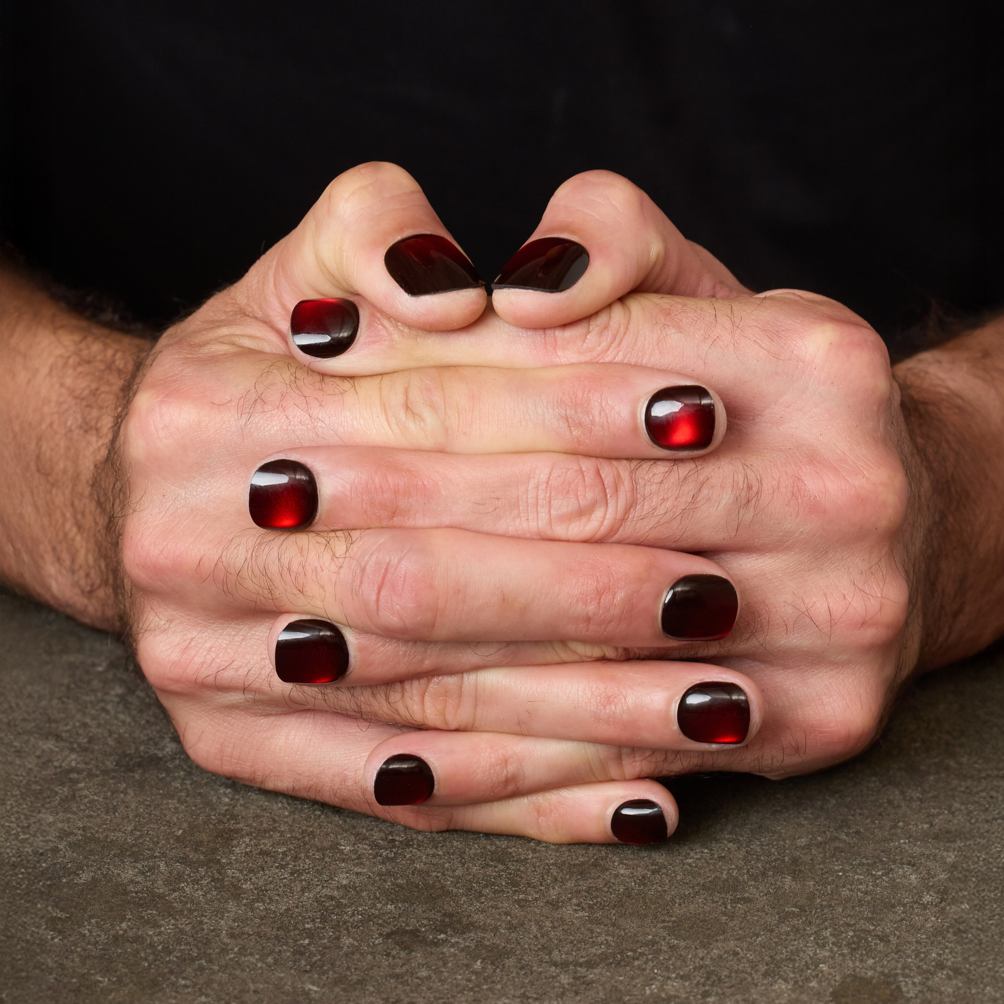 close up of crimson press on nails with liquid metal gleam 