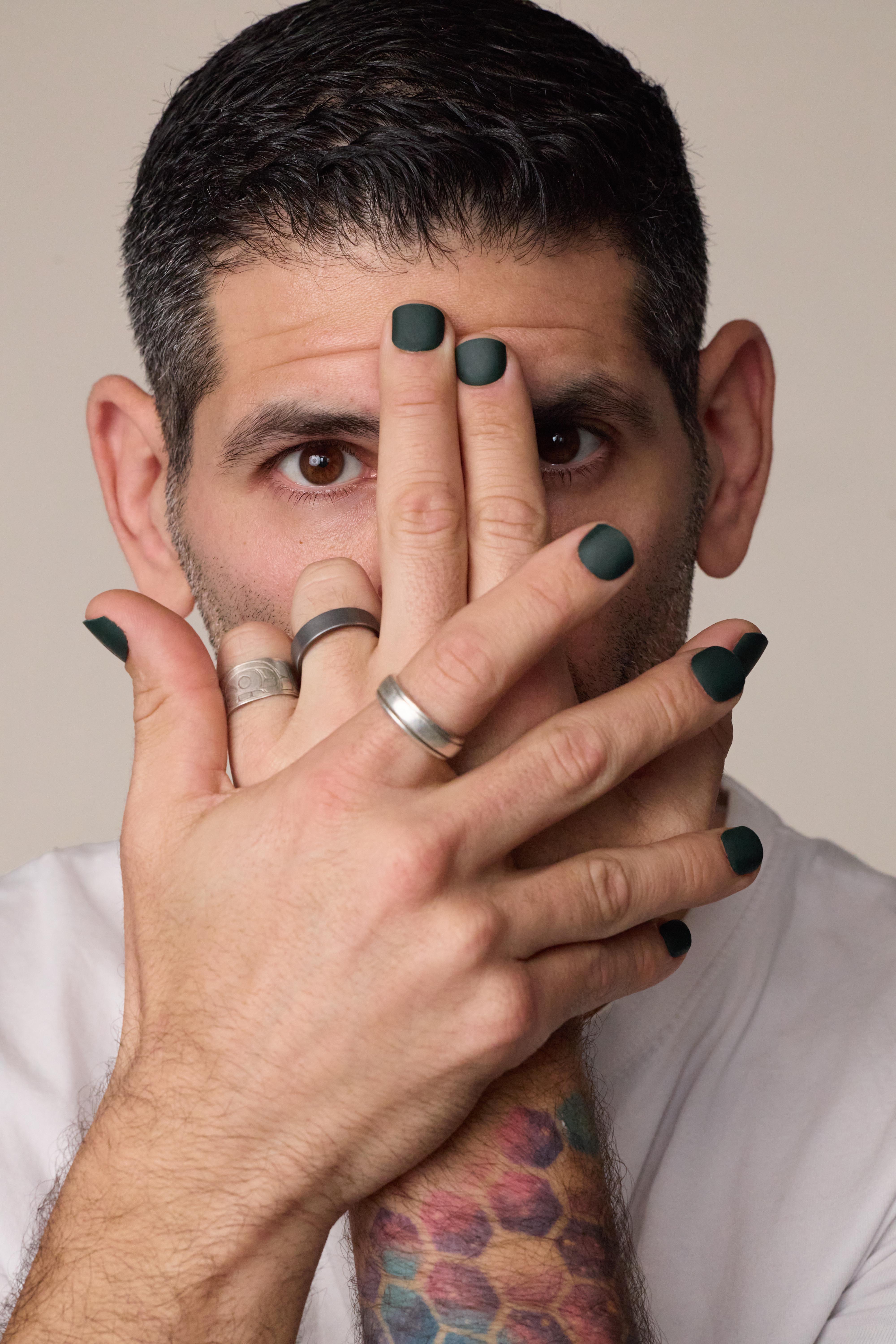 image of man in a white shirt showcasing men's press on nails in a matte hunter green color
