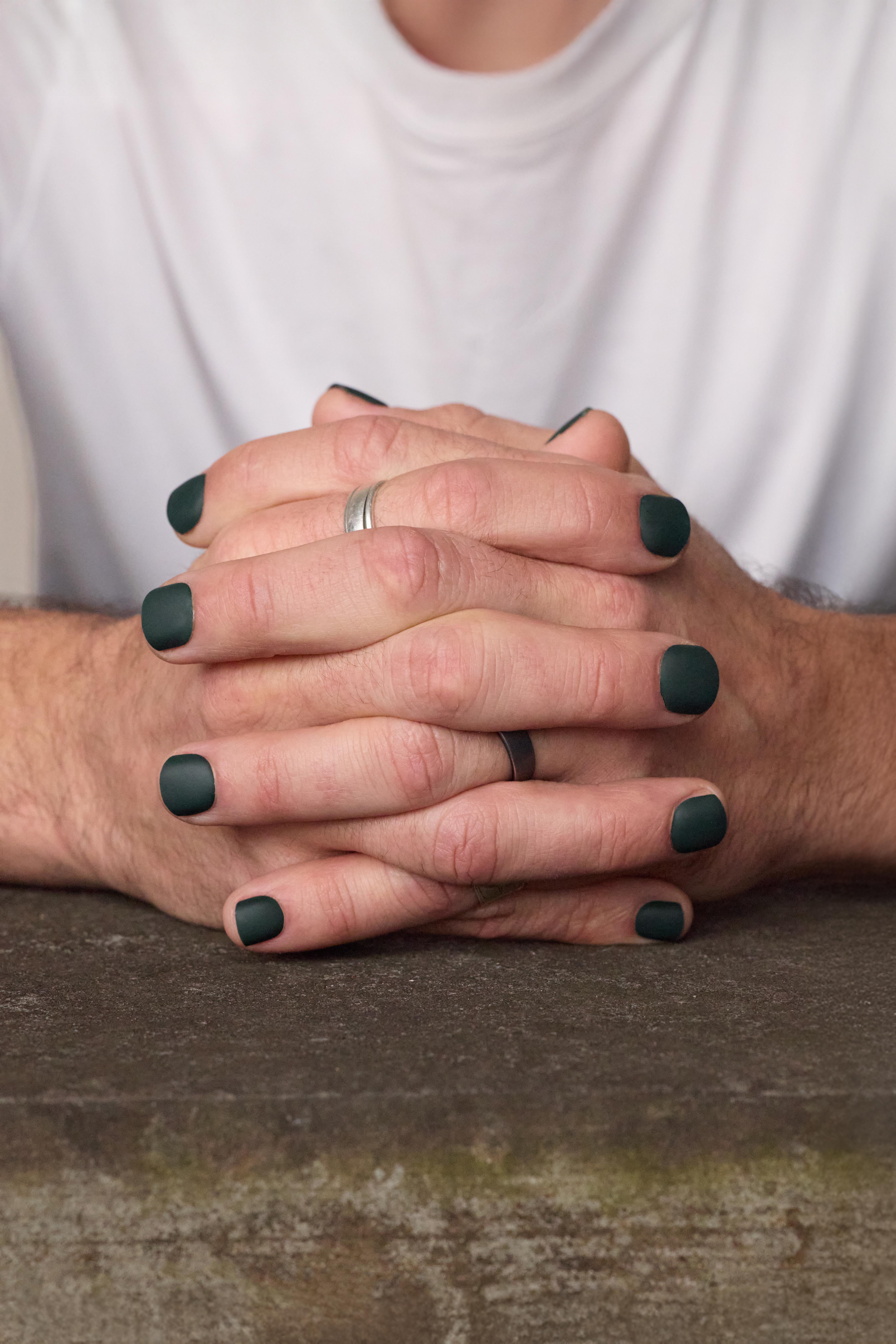 image of man with clasped hands showcasing men's press on nails in matte hunter green