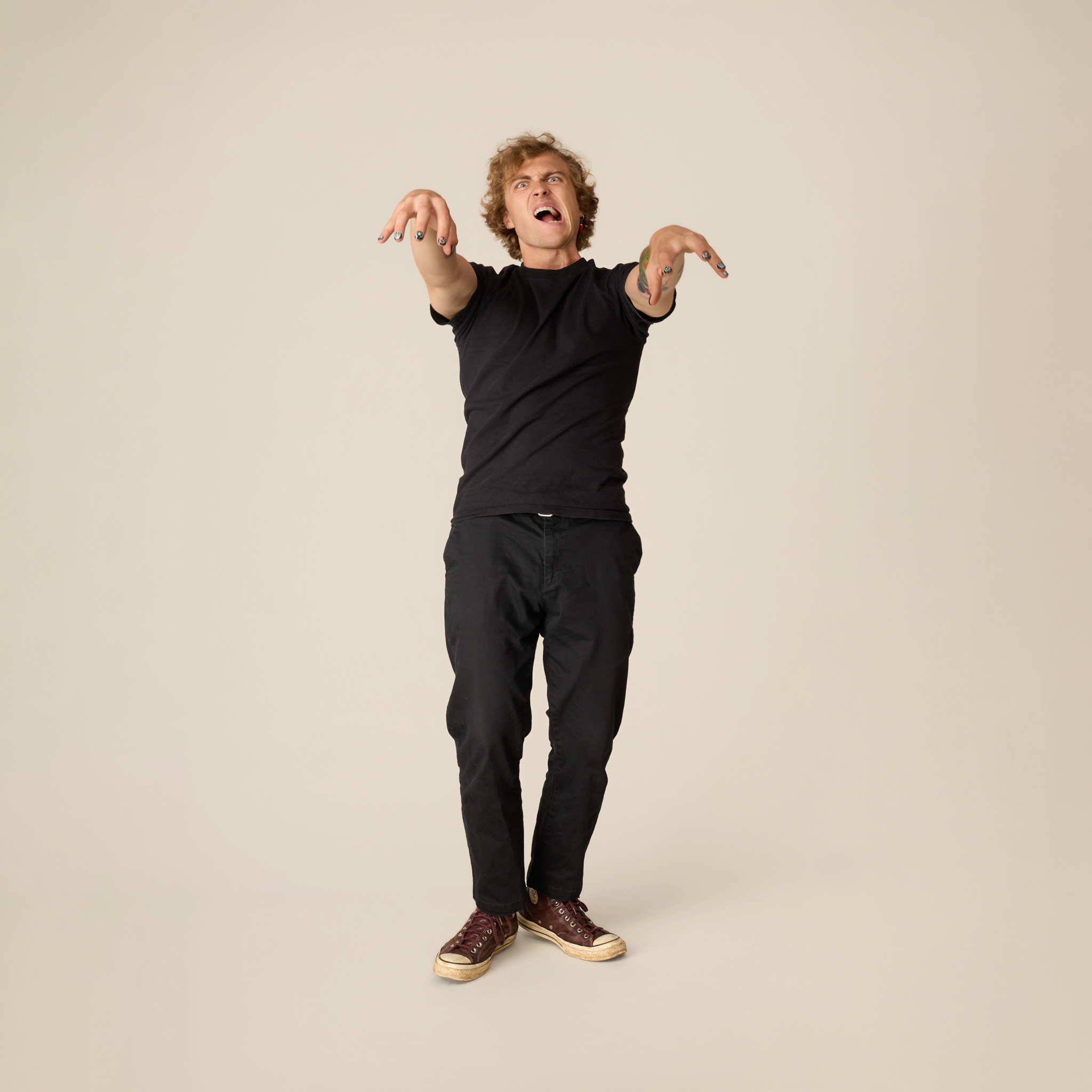 image of man in a spooky halloween pose  featuring press on nails in classic haunted house designs in a purple, green, and orange palette