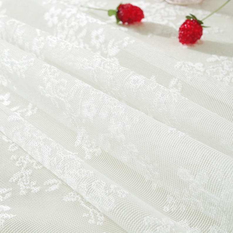 Nappe en dentelle blanche à broderies florales et volants