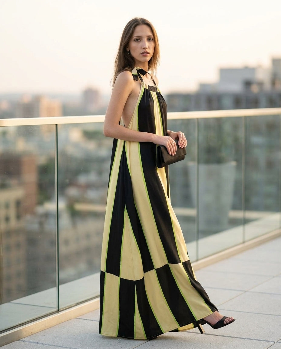 Black Grace Resort Striped Romper Black Romper with Relaxed Fit silhouette and Satin texture, outdoor styling image for Resort Wear, an estate dinner at golden hour, US East / Hamptons Elite by Mesadic