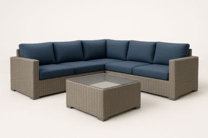 Set divano angolare in rattan con cuscini blu e tavolo in vetro