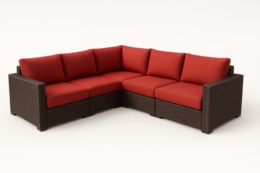 Divano angolare da esterno in vimini con cuscini rossi