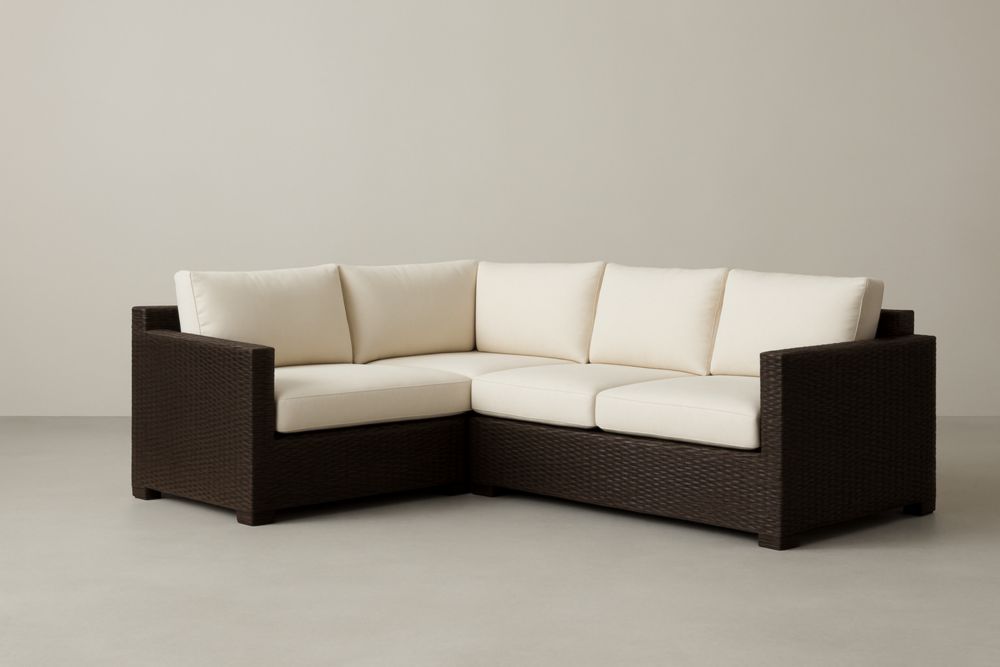 Divano angolare da giardino in rattan sintetico marrone con cuscini bianchi