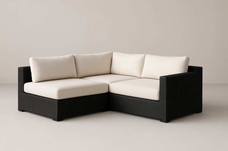 Canapé d'angle en résine tressée noire avec coussins beige pour jardin