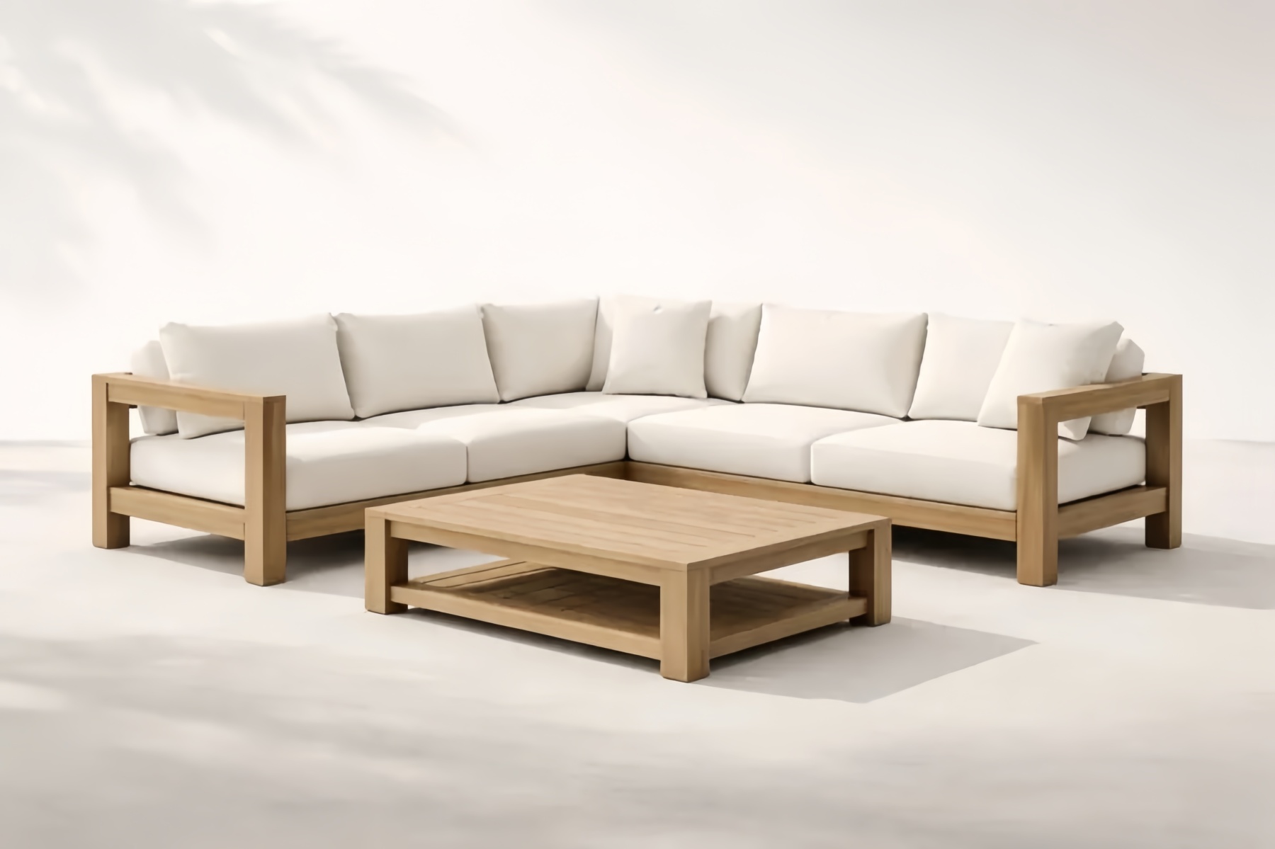 Divano angolare in legno massello con cuscini in tessuto bianco e tavolino abbinato